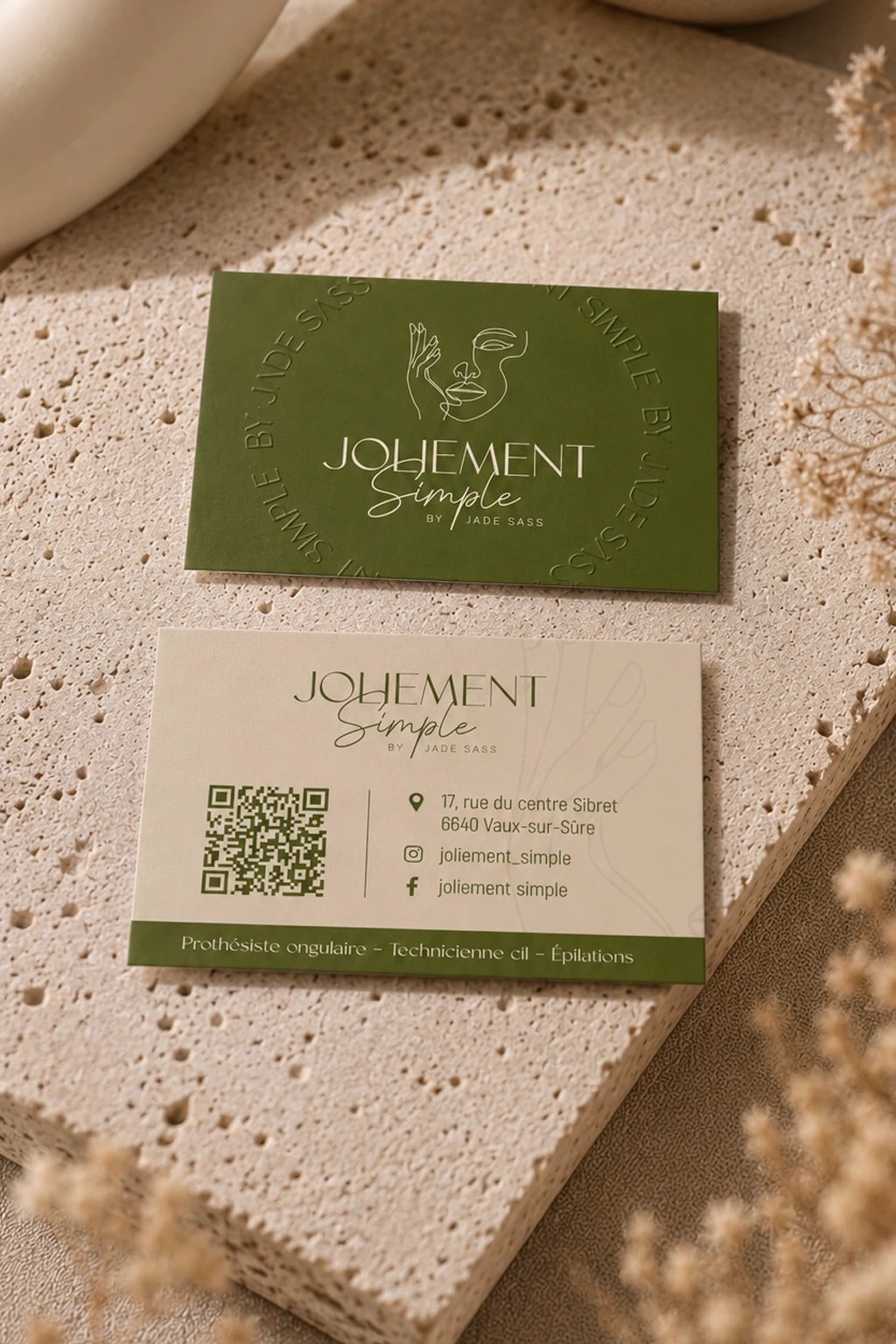 Cartes de visite Joliement Simple, vert olive et crème, posées sur une plaque de travertin